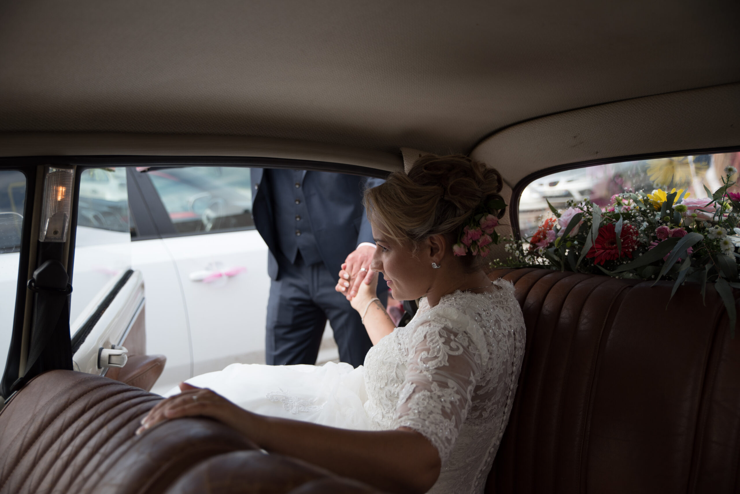 Mariée installée dans une voiture ancienne